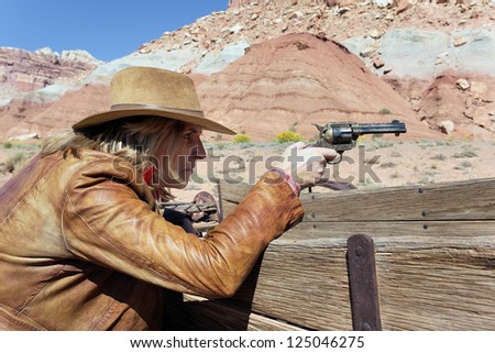 cowgirl with a gun in the hand, ready to shoot