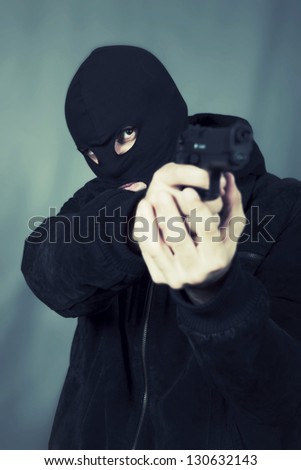 black dressed man with gun in studio
