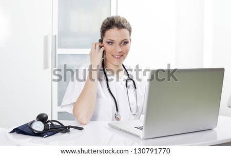 woman doctor in hospital with computer and phone