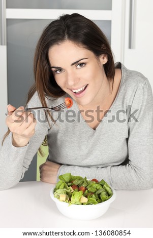 beautiful young girl eating healthy food at home