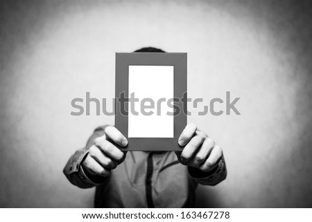 A young depressed man holding the picture frame, black&white