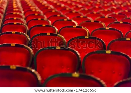 numbered theater chairs with red velvet