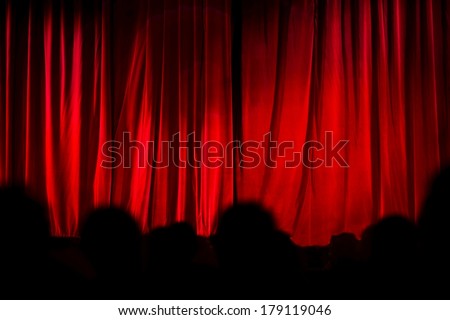 Theater curtain before the start of the performance with black silhouette of spectators