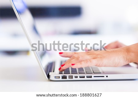 Businesswoman typing on the keypad of her laptop close-up