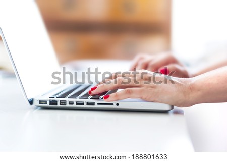 Businesswoman typing on the keypad of her laptop close-up