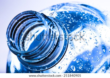 bottle neck with water drops on blue background