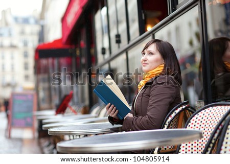 Beautiful young woman with a book in cafe