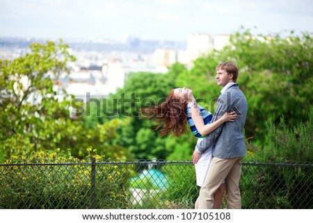 Sensual couple is hugging tenderly on Montmartre with nice view on Paris