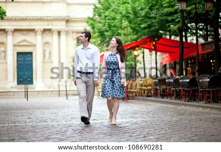 Couple walking in Paris near a street cafe