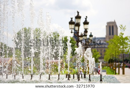 Summer in Paris. View of Notre-Dame de Paris through the fountain. Focus on the water jets