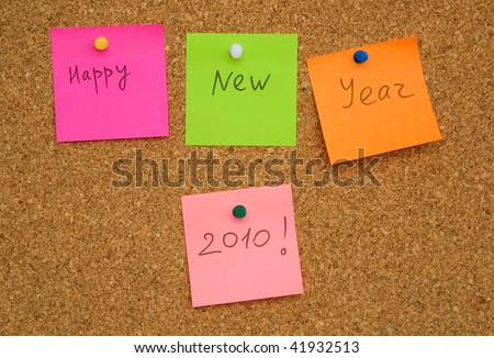 Adhesive paper note on cork board with words Happy New Year 2010
