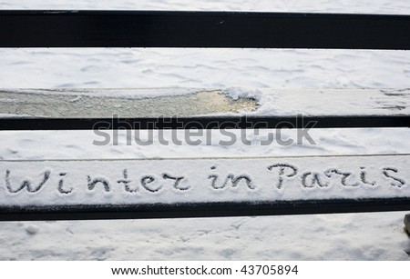 Rare snowy day in Paris. Handwriting on a bench covered with snow in the Luxembourg garden