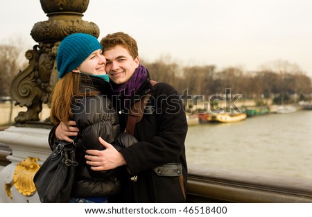 Happy loving couple in Paris hugging on the Pont Alexandre III