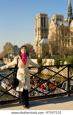 Happy beautiful woman in Paris near Notre-Dame de Paris, enjoying warm spring day
