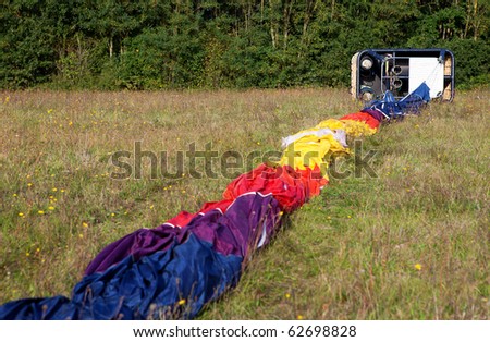 Wicker gondola and hot air balloon envelope on the ground, ready for the inflating
