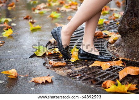 Autumn in Paris. Beautiful female legs and many bright autumn leaves