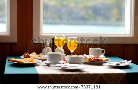 Delicious breakfast served on a table near the window at rainy day