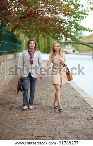 Romantic couple in Paris, walking by the embankment