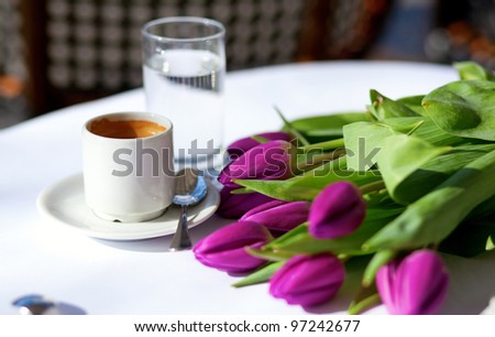 Spring coffee. Cup of fresh espresso and bunch of beautiful tulips