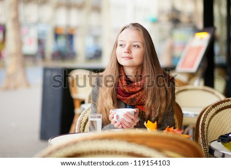 Pensive girl in a Parisian outdoor cafe