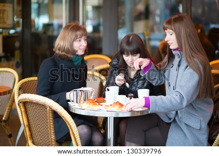 Friends in a Parisian street cafe, chatting