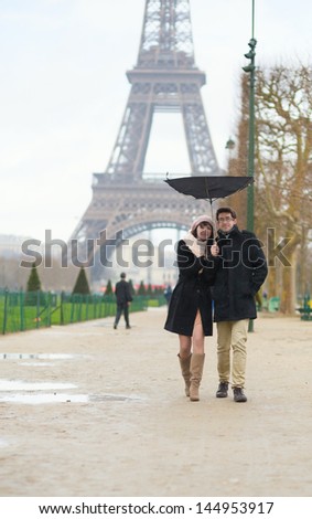 Couple walking under the rain with broken umbrella