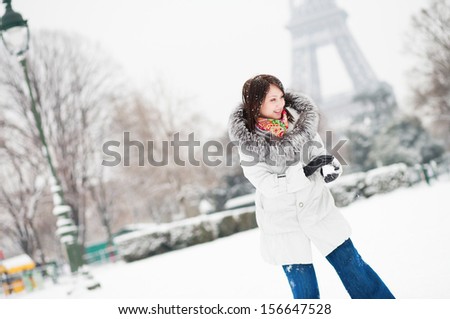 Girl playing snowball in Paris on a winter day