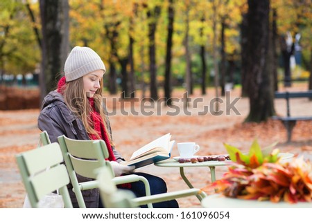 Girl reading a book in an outdoor cafe