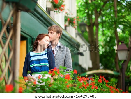 Man and woman together on balcony of their house or hotel with blossoming geranium and nice view