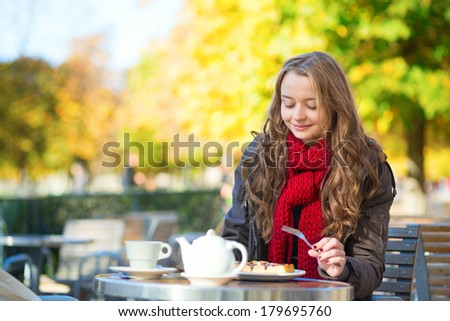 Girl eating waffles in a Parisian outdoor cafe