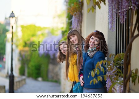 Three girls on a street of Montmartre, having fun