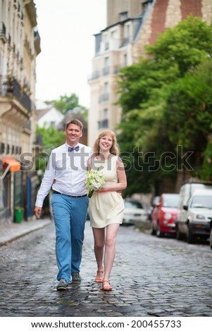 Happy just married couple walking on Montmarte in Paris