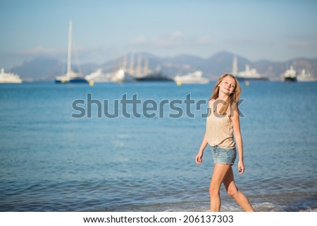Beautiful young girl enjoying her vacation by the sea