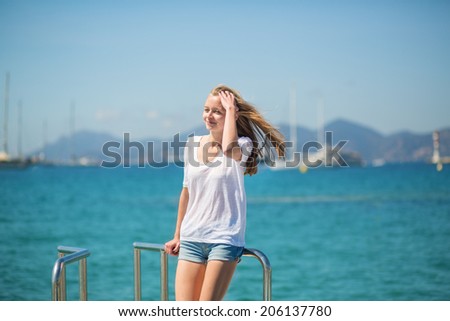 Beautiful young girl enjoying her vacation by the sea