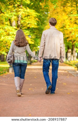 Couple in love walking together in park on a fall day