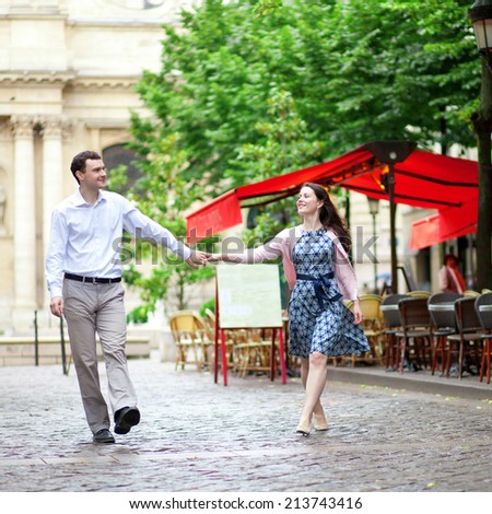 Couple walking in Paris near an outdoor cafe