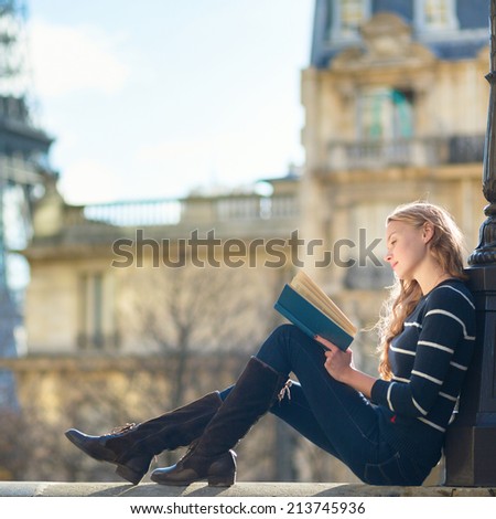 Beautiful young woman in Paris, reading a book