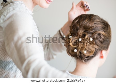 Young bride getting her hair done before wedding