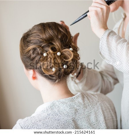 Young bride getting her hair done before wedding