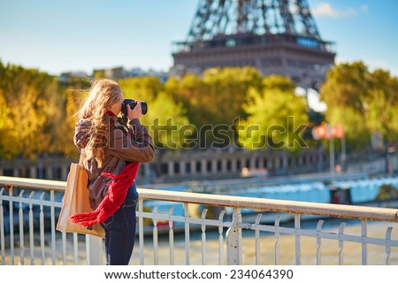 Young photographer taking picture of the Eiffel tower in Paris