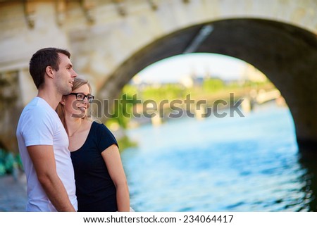 Young couple in Paris on the embankment of the Seine