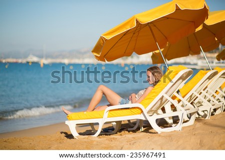 Beautiful girl relaxing on a beach chair near the sea