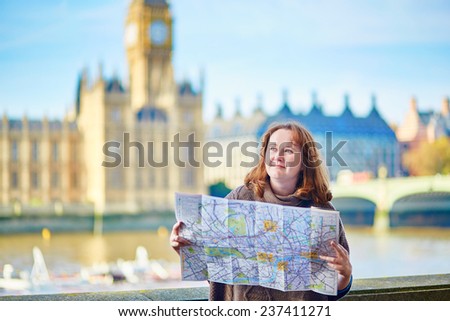 Tourist in London near Big Ben looking for direction using map