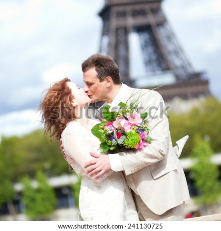 Wedding in Paris. Happy newlywed couple kissing near the Eiffel Tower