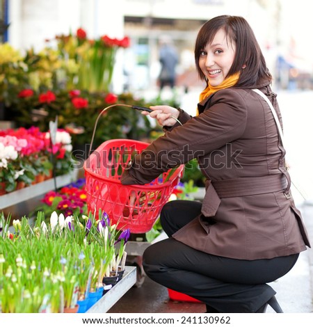 Beautiful young girl buying flowers at French flower market