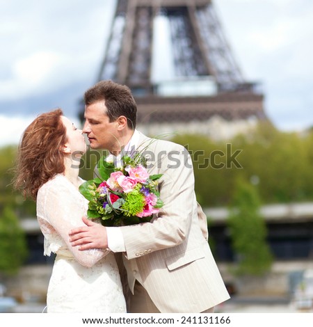 Just married couple is kissing near the Eiffel Tower