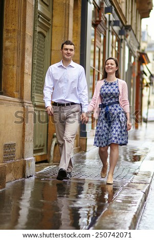 Couple in Paris walking together on a rainy day