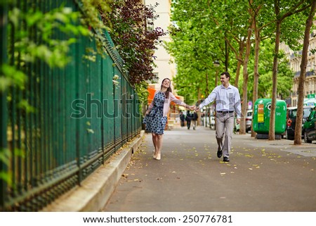Cheerful dating couple is walking in Paris