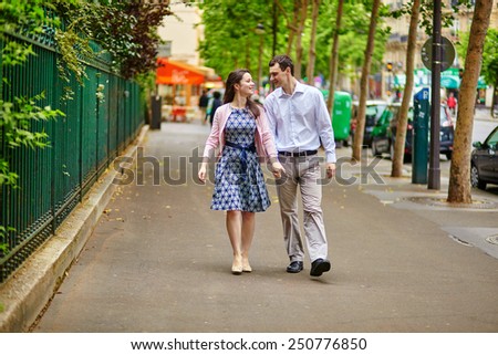 Cheerful dating couple is walking in Paris