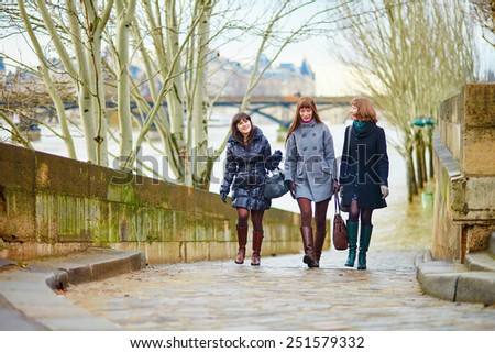 Three young cheerful girls walking together in Paris